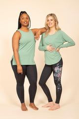 Deux femmes debout portant chandail, camisole et leggings écoresponsable Rose Buddha. /  Two women standing wearing Rose Buddha eco-responsible sweater, tank top and leggings.